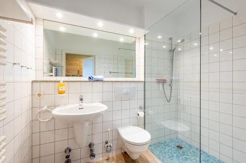 y baño con lavabo, aseo y ducha. en Steger-Hüs Wohnung 15, en Rantum