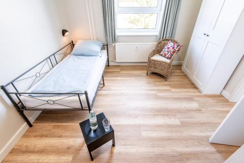 a small room with a bed and a chair at Steger-Hüs Wohnung 16 in Rantum