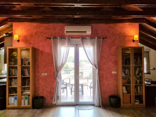 Zimmer mit einer Tür mit Vorhängen und einem Tisch in der Unterkunft Studio Loft Aridea in Aridea