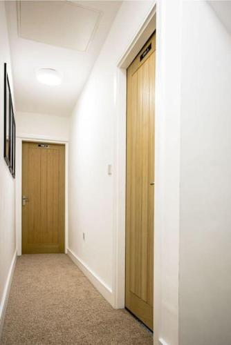 a hallway with two wooden doors in a building at Cruise Cruise Cribs - BERESFORD in Stoke on Trent