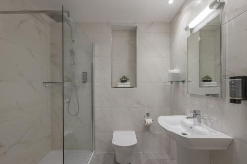 een badkamer met een douche, een toilet en een wastafel bij The Glenview Hotel & Leisure Club in Newtown Mount Kennedy