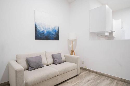 een witte woonkamer met een bank en een schilderij bij Nice apartment in Chamberí PON23 in Madrid