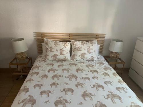 a bedroom with a bed with an elephant bedspread and two lamps at Marian’s House in Fuengirola