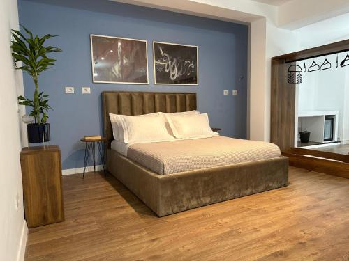 1 dormitorio con cama y pared azul en Scandinavian Apartments AL, en Tirana