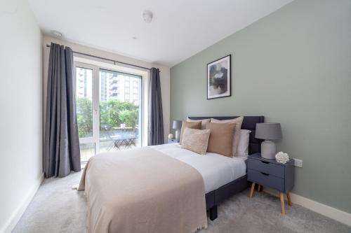 a bedroom with a bed and a large window at The River Thames Collection in London