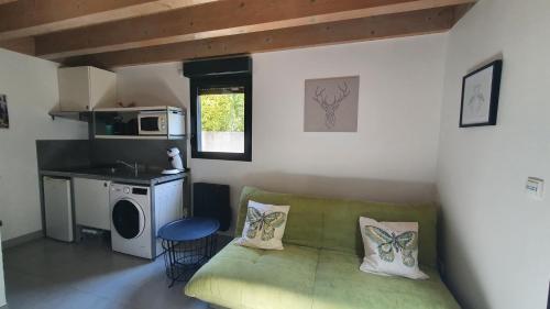 un salon avec un canapé vert et une cuisine dans l'établissement Le 30 - Duplex en rez-de-jardin proche du centre, à Montélimar