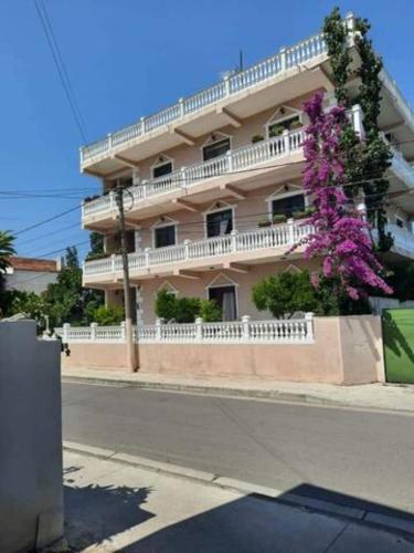 un bâtiment avec un arbre en fleurs devant dans l'établissement Vila Lika Durres, à Durrës