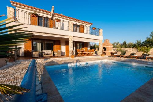 a large swimming pool in front of a house at Villa Sara - perfect family holiday in Krk