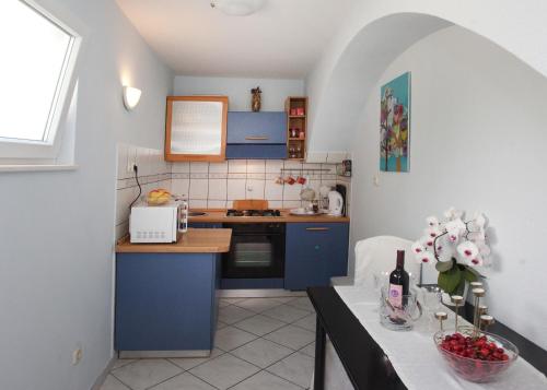 a small kitchen with blue cabinets and a table at Apartment Zoky in Split