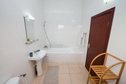 a bathroom with a tub and a sink and a mirror at Appartement Charmant et Lumineux in Pointe-Noire