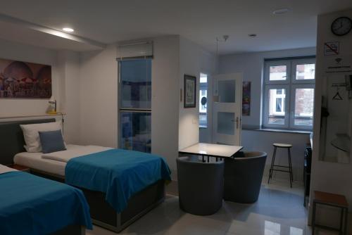 sypialnia z 2 łóżkami, stołem i biurkiem w obiekcie ROOMS BYTOM w Bytomiu