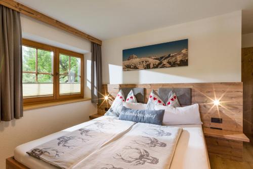 Un dormitorio con una cama grande y una ventana en Landhaus Exenberger / Ferienwohnung Smaragd, en Bramberg am Wildkogel