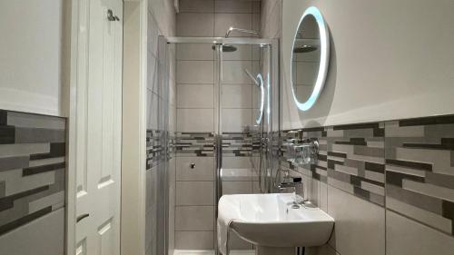 a bathroom with a sink and a shower with a mirror at ANFIELD PLACE TO STAY in Liverpool