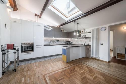 a large kitchen with white cabinets and a wooden floor at Cottage near Ferrari's City & Pavarotti's House in Montale
