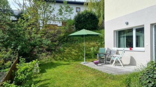 a patio with an umbrella and a table and chairs at Studio Bike & Snow in Innsbruck