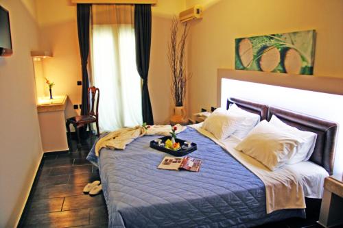 Un dormitorio con una cama con una bandeja de comida. en Samos Bay Hotel by Gagou Beach en Samos