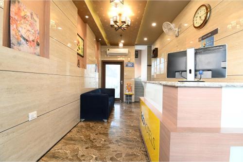 a lobby with a bar with a clock on the wall at FabHotel 7th Crossing Malviya Nagar in Jaipur
