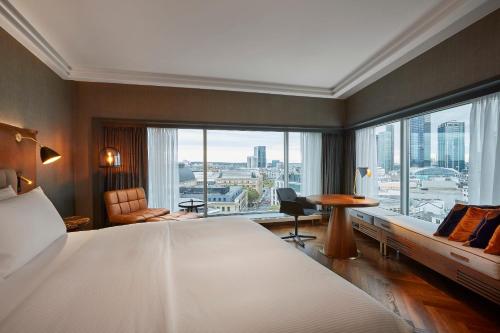 a hotel room with a large bed and a large window at Hilton Frankfurt City Centre in Frankfurt/Main