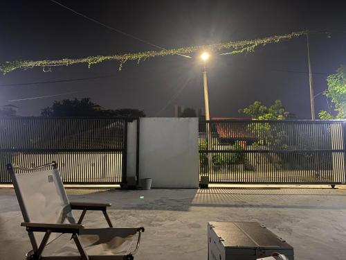 a chair sitting in front of a fence at night at Sweet Loft Homestay in Johor Bahru