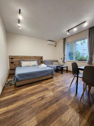 een slaapkamer met een bed en een tafel en stoelen bij Malavi TN1 top center studio Ruse in Ruse
