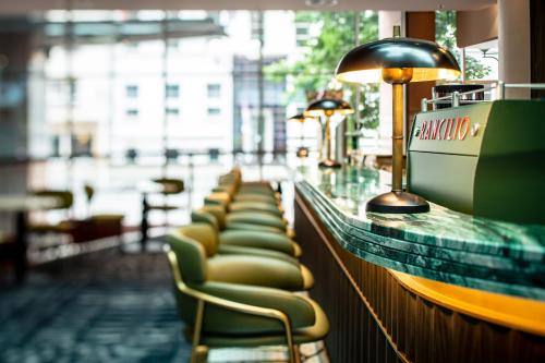 a row of chairs on a bar in a restaurant at Hilton Frankfurt City Centre in Frankfurt/Main