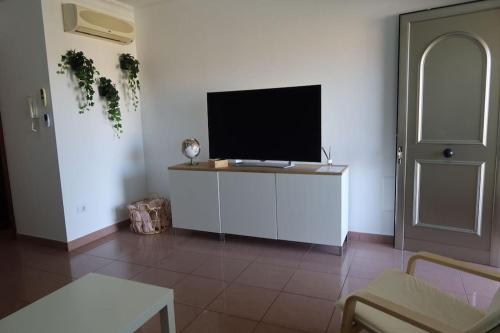 a living room with a flat screen tv on a white wall at Brisas de Puerto Rico in Puerto Rico de Gran Canaria