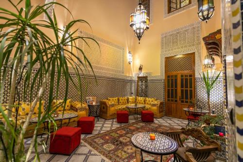 una hall con divani, tavoli e una pianta in vaso di Riad Diamant De Fes a Fes