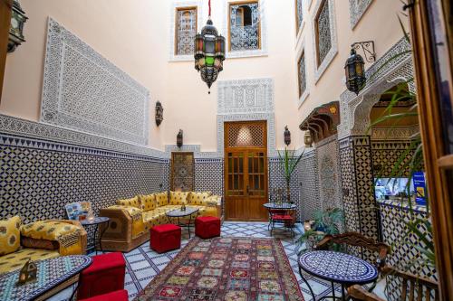 a living room with couches and tables at Riad Diamant De Fes in Fès