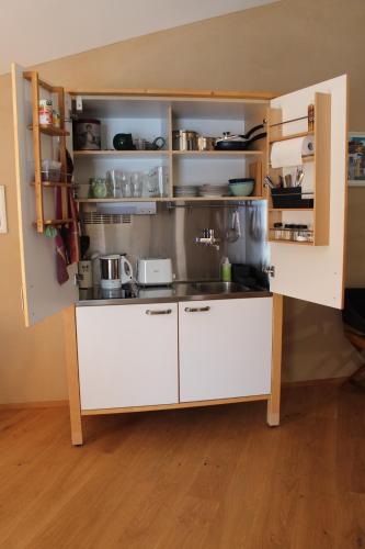 a small kitchen with white cabinets and appliances at Ferienwohnung Kallmünz_Luftschloss in Kallmünz