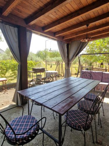 een houten tafel en stoelen op een patio bij La casa di Giulia in Bronte