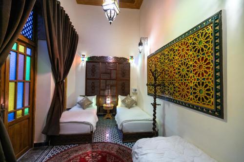 a living room with two beds and a window at Riad Diamant De Fes in Fès