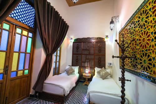 a room with two beds and a window at Riad Diamant De Fes in Fès