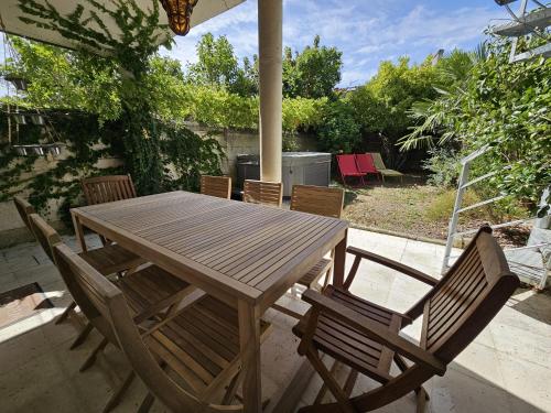 une table et des chaises en bois sur une terrasse dans l'établissement Le Bienheureux, le calme en ville et jardin, à Angoulême