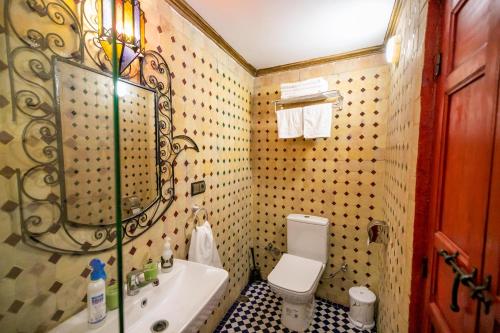 a bathroom with a sink and a toilet and a tub at Riad Diamant De Fes in Fès