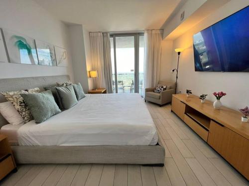 ein Schlafzimmer mit einem großen Bett und einem TV in der Unterkunft King bed kitchen and dining area Apmt in Miami in Hallandale Beach