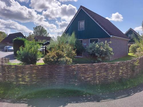 una casa con una pared de ladrillo y una valla en 't Zyper Eilant 123, en Oudesluis
