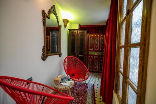 a room with two red chairs and a table at Riad Diamant De Fes in Fès