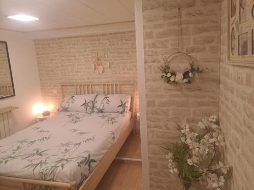 une chambre avec un lit et un mur de briques dans l'établissement Bienvenue chez nous, à Saint-Martin-de-Brômes