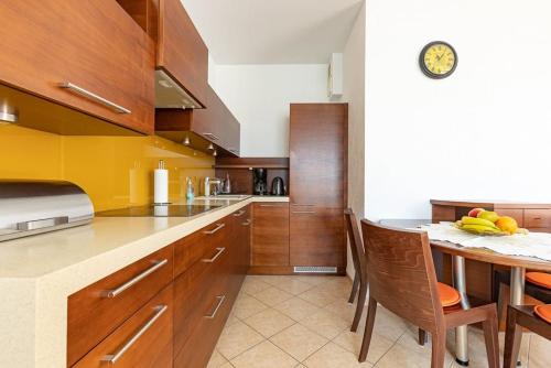 a kitchen with wooden cabinets and a table with chairs at APARTMENT IN THE HEART OF GDAŃSK in Gdańsk