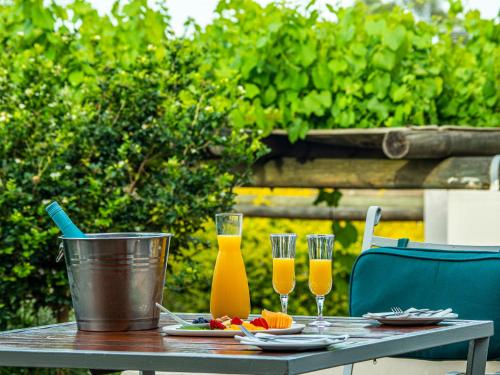 una mesa de madera con 2 vasos de zumo de naranja en Diemersfontein Wine & Country Estate, en Wellington