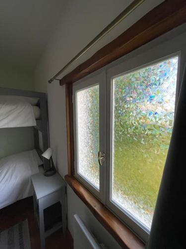 a window in a bedroom with a view of a bed at Le Gîte de L'Orée du Morvan in Montberthault