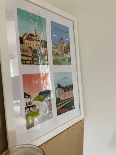 a picture frame with pictures of buildings on a wall at Le Gîte de L'Orée du Morvan in Montberthault