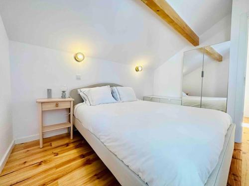a bedroom with a large white bed and a wooden floor at New Amaizing Cozy House in the heart Lisbon in Lisbon