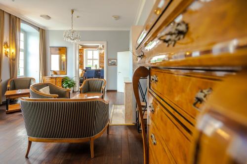 ein Wohnzimmer mit einem Tisch, Stühlen und einem Schreibtisch in der Unterkunft Hotel Prinzenpalais Bad Doberan in Bad Doberan