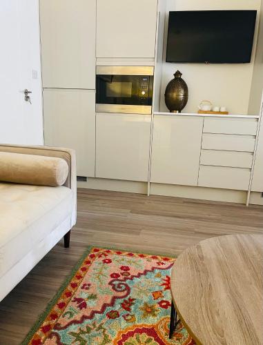 a living room with a couch and a table at Riverside Premium Double Room Garden View E14 in London