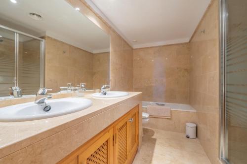 La salle de bains est pourvue de 2 lavabos, d'une douche et d'une baignoire. dans l'établissement Two Bedroom Apartment In La Manga Club, à Atamaría