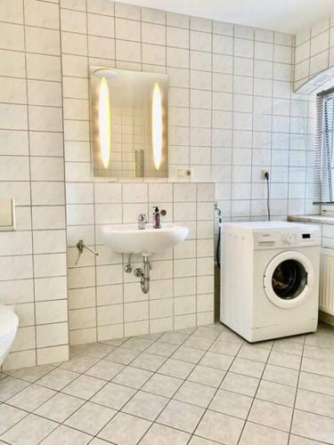 a bathroom with a sink and a washing machine at Wanderurlaub mit Hund in Harra