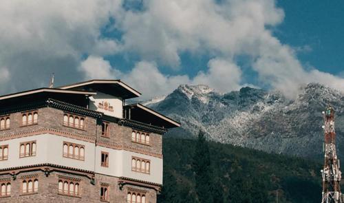 a building with a mountain in the background at Hotel Amodhara in Thimphu