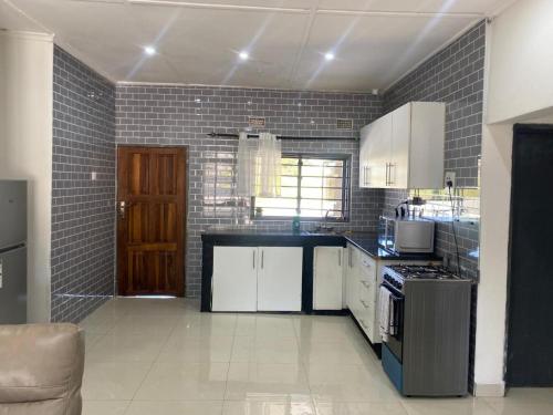 a kitchen with white cabinets and a black counter top at Swiss Luxury Apartments in Ndola