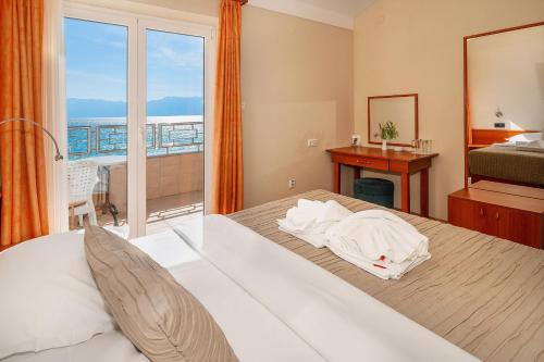 1 dormitorio con 1 cama y vistas al océano en Hotel Dobrovit ex Tamaris, en Baška